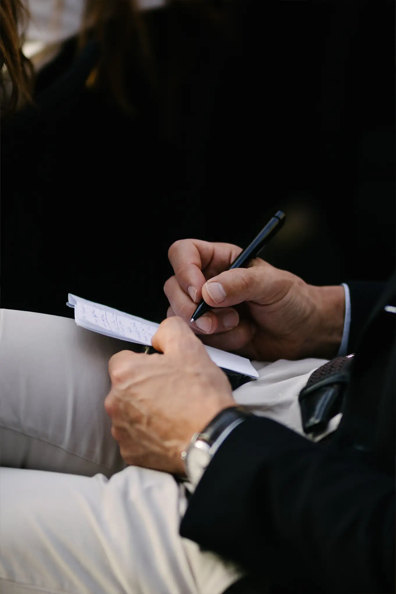 Une main écrit sur une feuille de papier